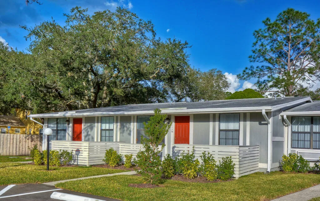 Single-story Live Oak apartment homes with private red entry doors